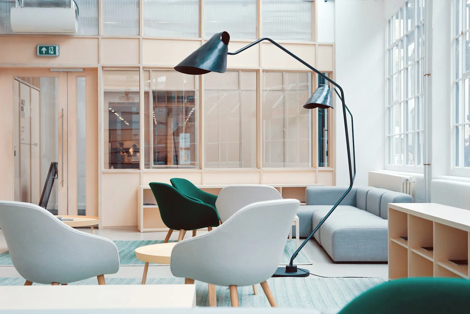 Zithoek met fauteuils en een vloerlamp in een kantoor