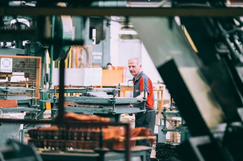 Medewerker bedient een machine in een fabriek