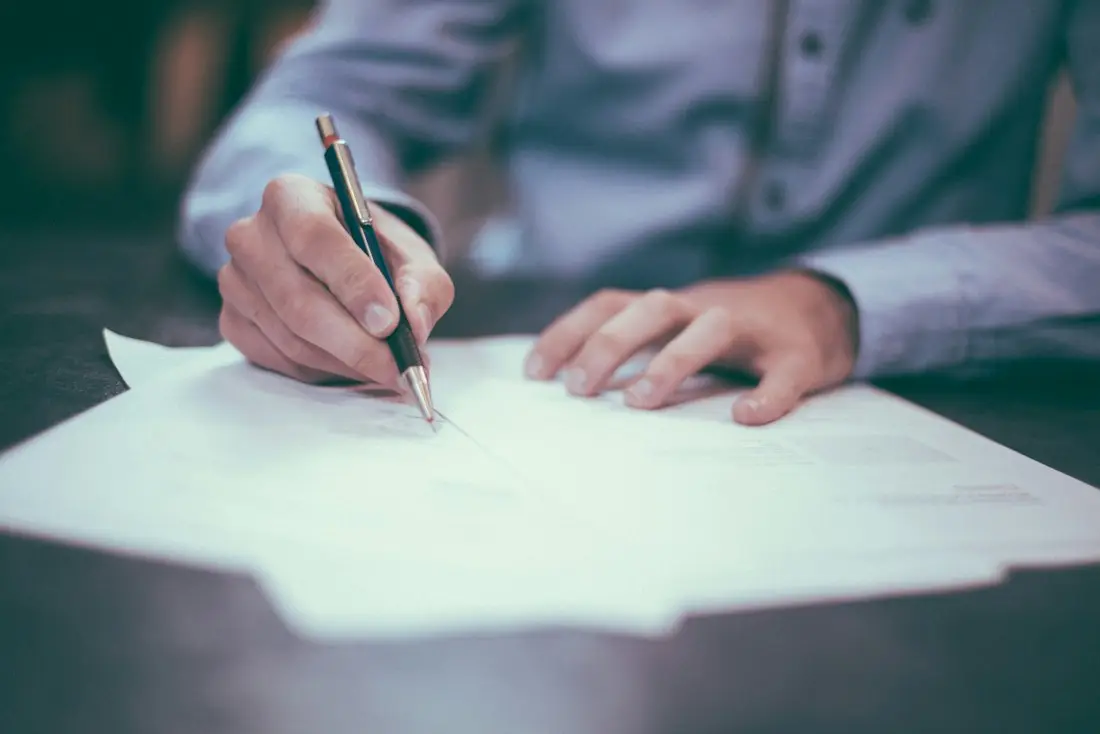 Iemand zet een handtekening onder een document